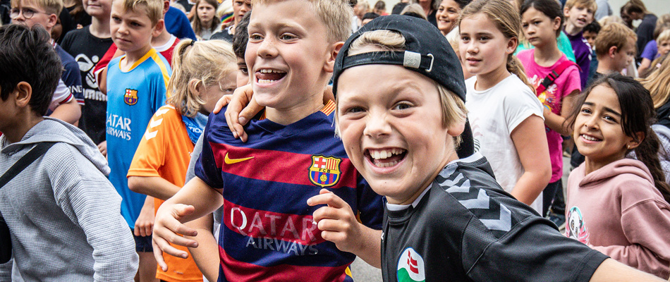 Glade børn ved opvarmningen til skolens idrætsfest i 2023